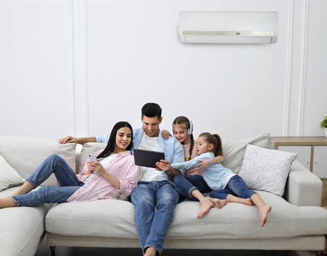 family sitting under a split system air conditioner
