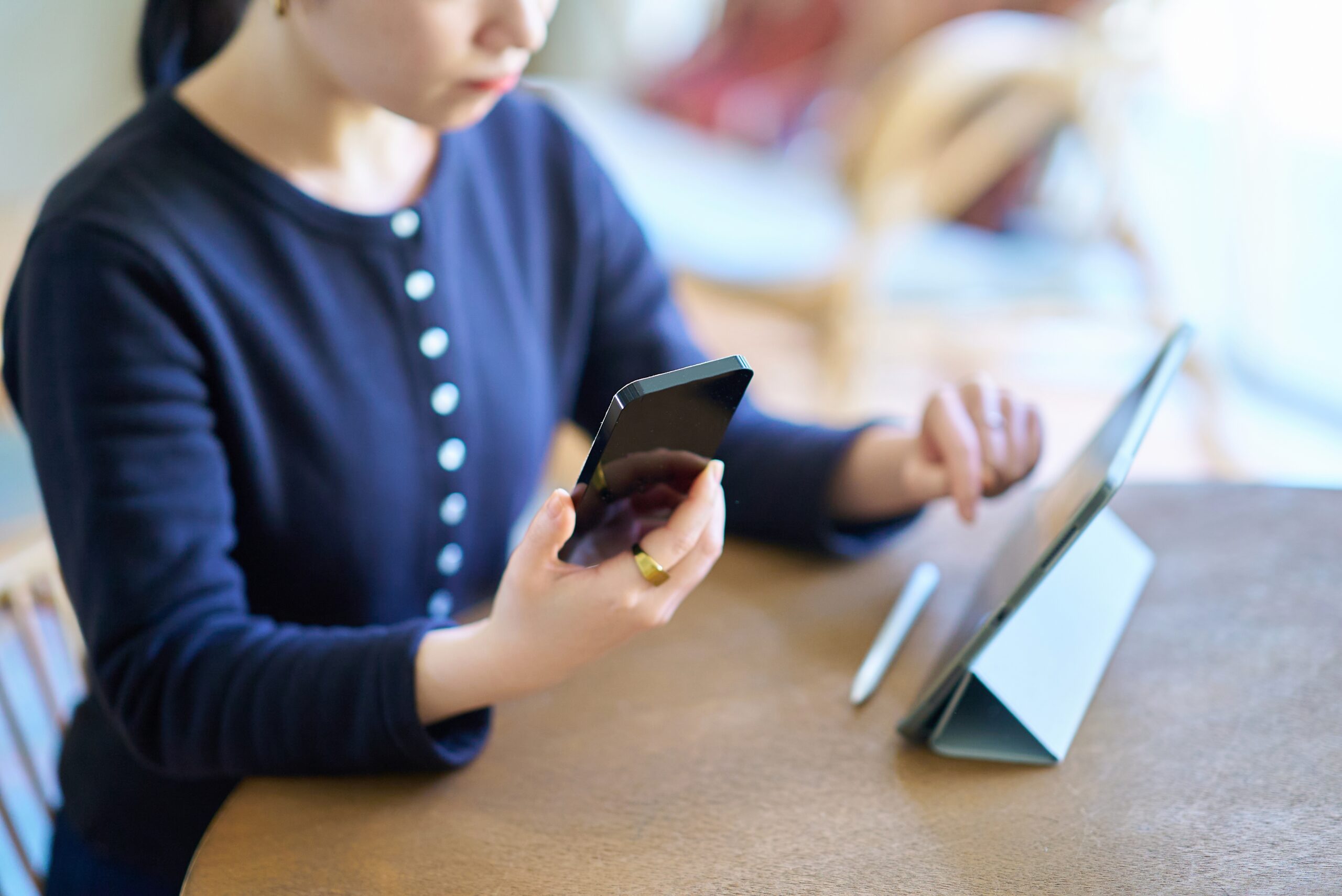 Young Woman Comparing Tablet and Phone